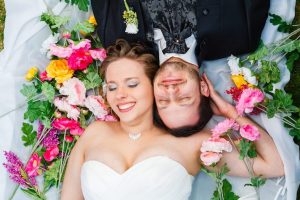 Hochzeitspaar liegt auf einer bunten Blumenwiese