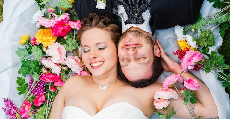 Hochzeitspaar liegt auf einer bunten Blumenwiese